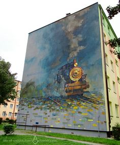 a large mural on the side of a building with a train coming down it's track