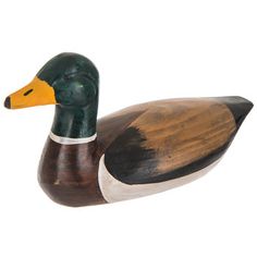 a wooden duck sitting on top of a white surface next to a green and yellow head