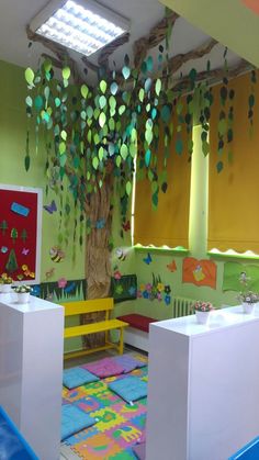 a child's playroom with colorful rugs and paper trees on the wall