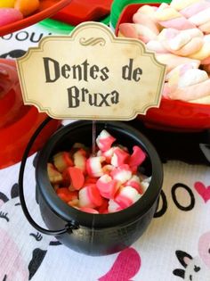 there is a sign that says dentes de bruxa next to bowls of candy