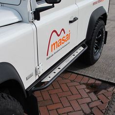 a white truck parked on the side of a road next to a brick walkway and parking meter