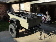 an off - road vehicle parked in front of a house next to a bicycle rack