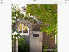 an image of a small house with flowers on the front door and in the back yard