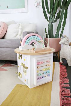 a room with a couch, rug and table in it that has toys on top of it