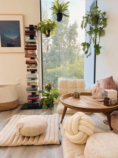 a living room filled with lots of furniture and plants on top of the windowsill