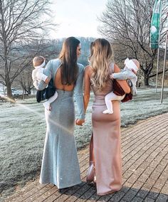 two women and a baby are walking down the street