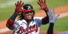 a baseball player with his hands up in the air