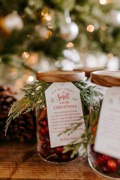 two glass jars filled with candy sitting on top of a table next to a christmas tree