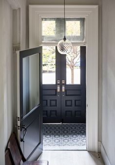 an open door leading into a room with a light fixture hanging from it's ceiling