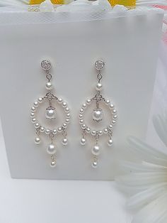 Formal White Pierced Chandelier Earrings, White Pierced Chandelier Earrings For Formal Occasions, Elegant White Clip-on Chandelier Earrings, Elegant Formal Chandelier Earrings With Dangling Beads, Elegant Wedding Crystal Earrings With Dangling Beads, Elegant White Round Chandelier Earrings, White Pierced Chandelier Earrings For Anniversary, Formal Pearl Drop Chandelier Earrings, Formal Round Chandelier Earrings With Pearl Drop