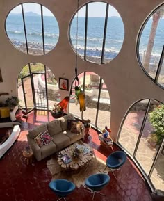 a living room with large round windows overlooking the ocean