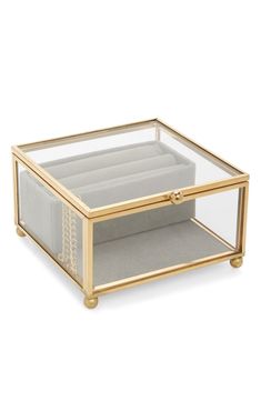 a glass and gold coffee table with an open drawer