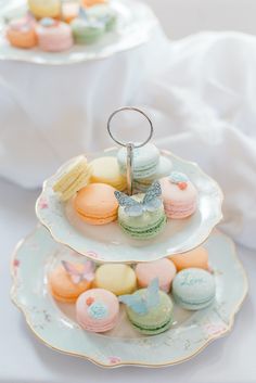 two plates with macaroons on them and one has a wedding ring in the middle