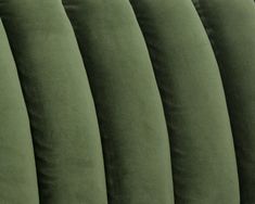 the back end of an upholstered couch with green velvet material and pleated edges