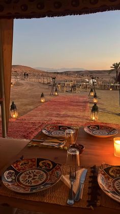 an outdoor dining area with candles and plates