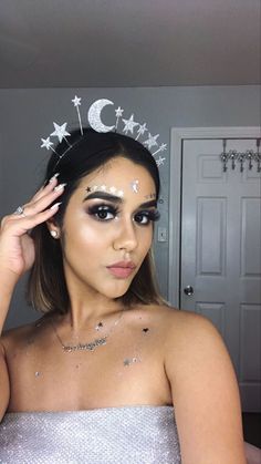 a woman wearing a tiara with stars on it's head and silver makeup