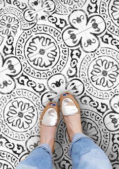 a person standing in front of a black and white tile floor with their feet on the ground