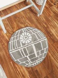 a star wars themed rug is on the floor next to a white chair and table