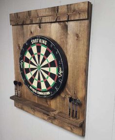 a dart board mounted to the side of a wooden wall hanging on a white wall