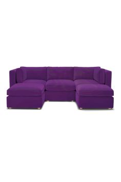 a purple sectional couch sitting on top of a white floor