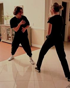 a man and woman are standing in the middle of a dance floor, facing each other