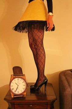 a woman standing on top of a wooden table next to a clock and skirted shirt