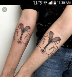 two people with tattoos on their arms holding hands