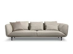 a white couch with many pillows on it's back and side ends, sitting in front of a white background