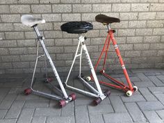 two scooters sitting next to each other on top of a brick floor in front of a wall