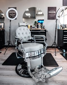 a barber chair sitting on top of a hard wood floor next to mirrors and lights