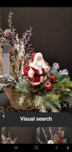 an image of a christmas arrangement with santa clause and pine cones on it's side