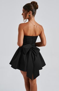 THE dress of the season has landed and you're going to be obsessed. Meet Katrina, our dreamy mini with a pretty, voluminous skirt and waist cinching bodice. Fastening with a zip to the back, tie with an oversized bow to complete the look for perfect feminine drama. 



Colour: Black.

Premium non-stretch cotton blend fabric.

Fully lined.

Strapless ruched bodice with boning.

Waist cinching.

Oversized tie to create bow detail to back.

Voluminous skirt with tulle lining.

Zip fastening to the reverse.

Mini length.

 Size: XS, S, M, L, XL, XXL Ruched Mini Dress For Prom, Prom Mini Dress With Ruched Bodice, Ruched Mini Length Bubble Dress For Evening, Cocktail Dress With Gathered Voluminous Skirt, Ruched Mini Bubble Dress For Evening, Cocktail Dress With Voluminous Gathered Skirt, Ruched Mini Corset Dress For Cocktail, Cocktail Mini Corset Dress With Ruched Detail, Pleated Bodice Mini Dress For Prom