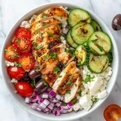 a white bowl filled with chicken, rice and vegetables