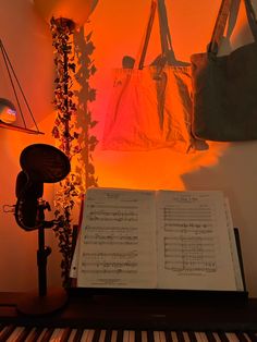 an open book sitting on top of a piano next to a bag and musical notes