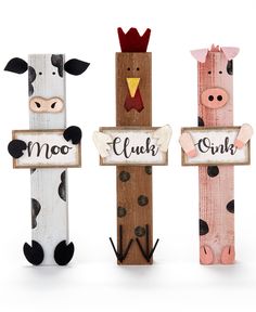 three wooden signs with farm animals on them and the words moo, cluck, cow