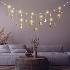 a living room with a couch, table and string lights hanging from it's ceiling