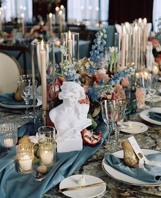 the table is set with candles, plates and napkins for an elegant wedding reception