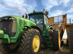 a green tractor parked on top of a dry grass field