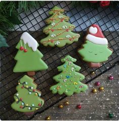 decorated christmas cookies sitting on top of a cooling rack