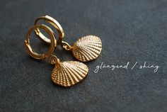 "Gold plated earrings with shell pendants. You can choose from two different earhooks (see picture number 2): 1: 12 mm hooks 2: 16 mm Creoles Also you can choose the style of the shell-charms: matt shiny M A T E R I A L gold-plated brass S I Z E Shiny gold plated Creoles: 0.6 inch / 16 mm in diameter Shiny gold plated Leverbacks: 12 mm in diameter Matt or shiny gold plated Shell pendants: 10 x 12 mm ------------------------------------------------------------------------------------------------- Elegant Shell Drop Earrings As Gift, Elegant Shell Drop Earrings For Gift, Elegant Drop Shell Earrings As A Gift, Elegant Gold Dangle Shell Earrings, Elegant Gold Dangle Shell, Gold Shell With Matching Earrings Gift, Elegant Gold Shell With Lobster Clasp, Elegant Gold Shell As Gift, Gold Nickel-free Shell As Gift