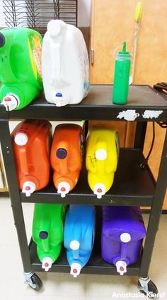 several different colored plastic jugs are sitting on a cart