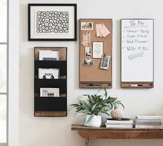 there is a bulletin board on the wall next to a potted plant and books