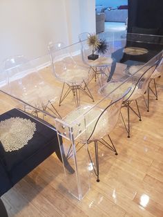 a glass table with four chairs around it