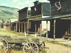 an old western town with wooden buildings and wagons