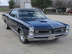 an old muscle car parked in a parking lot