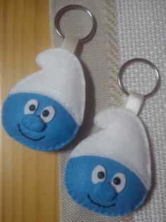 two blue and white keychains with faces on them sitting next to each other