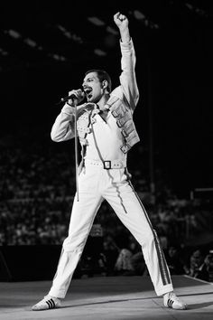 elvis presley singing into a microphone on stage at a concert in front of an audience