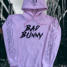 Brand New (Nwot) Bad Bunny Hoodie (Light Pink) With Bad Bunny On The Front, Bunny Ears On The Hood And Bunnies Down The Sleeves (Black). Pink Cotton Hoodie With Adjustable Hood, Casual Pink Hoodie With Ribbed Cuffs, Urban Pink Tops For Spring, Urban Style Pink Tops For Spring, Pink Adjustable Hood Sweatshirt For Spring, Pink Spring Sweatshirt With Adjustable Hood, Spring Pink Sweatshirt With Adjustable Hood, Urban Pink Cotton Sweatshirt, Pink Urban Hoodie With Letter Print