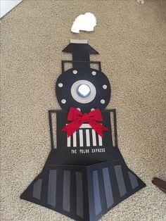 a paper cut out of a train with a red bow