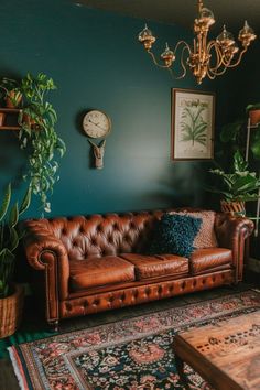 a brown leather couch sitting in a living room next to a table and potted plants